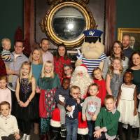 Alumni families posing with Louie and Santa Claus